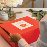 Person opening a Bona Furtuna Olive Oil Gift set on kitchen table