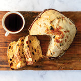 Panettone with white icing on a table with coffee.